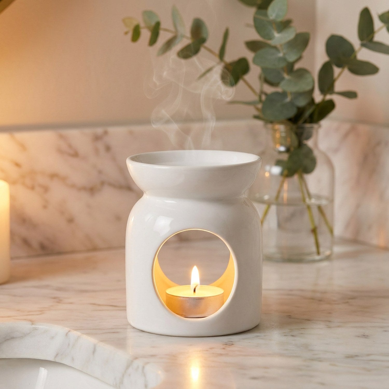 Gros plan brûle-parfum céramique sur étagère marbre avec eucalyptus