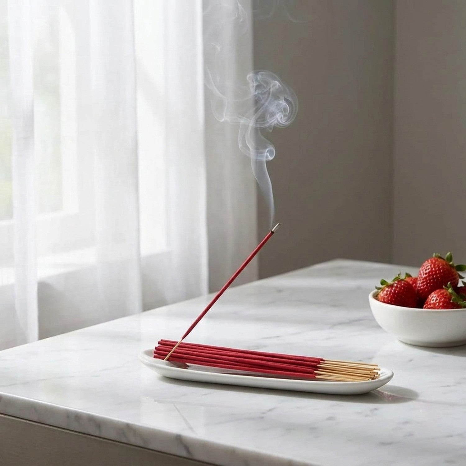 Bâtons d'encens rouge brûlant sur surface marbre blanche près fenêtre voilage zen