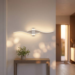 Applique murale blanche double courbe LED au dessus d'une console dans une entrée lumineuse