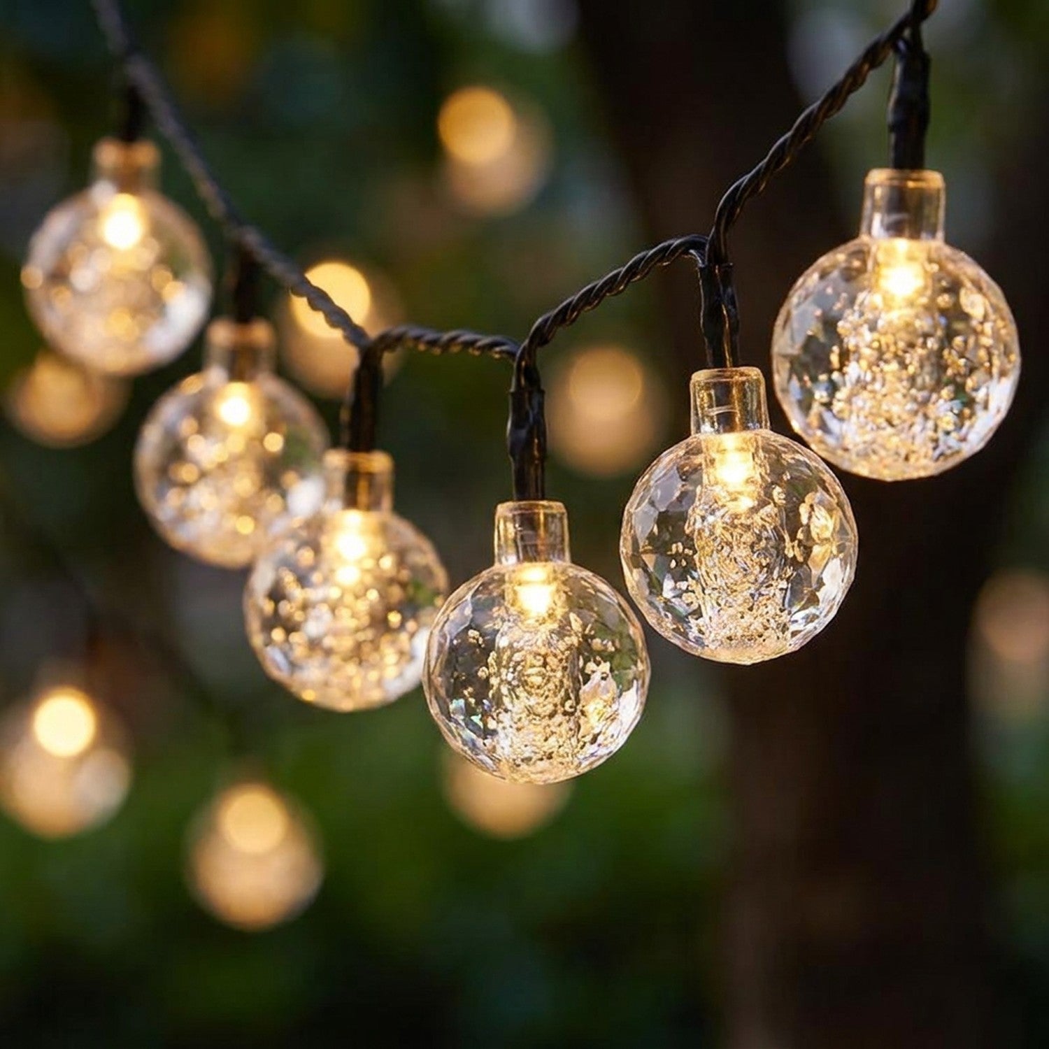 Gros plan boules cristal guirlande LED solaire lumière chaude bokeh