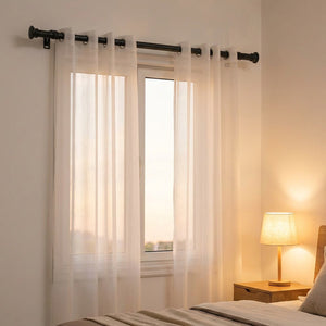 Tringle à rideau noire dans une chambre moderne avec voilage blanc et lampe de chevet