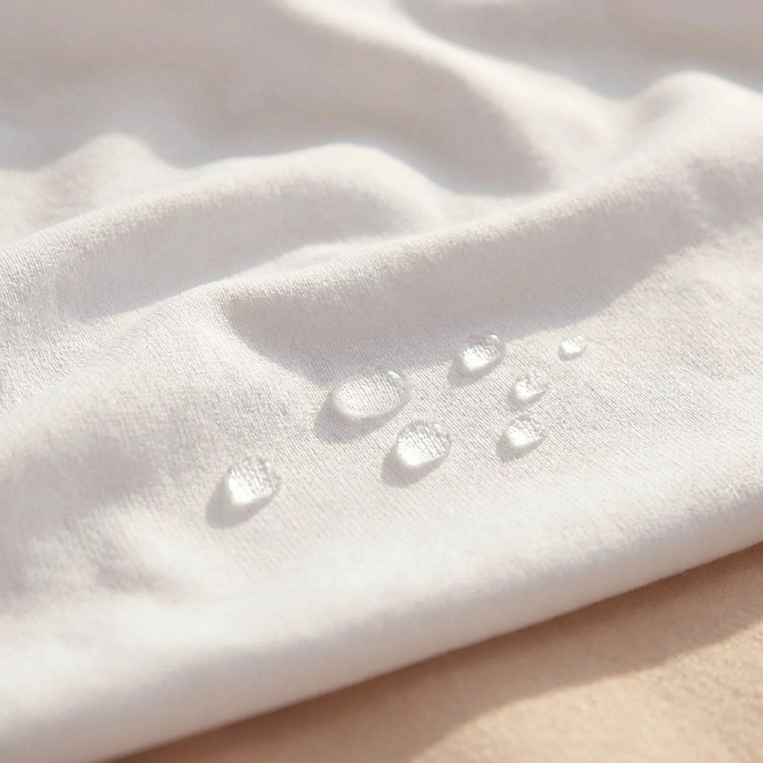 Gros plan sur le tissu blanc de la housse avec des gouttes d'eau perlées