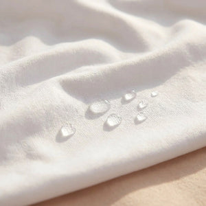 Gros plan sur le tissu blanc de la housse avec des gouttes d'eau perlées