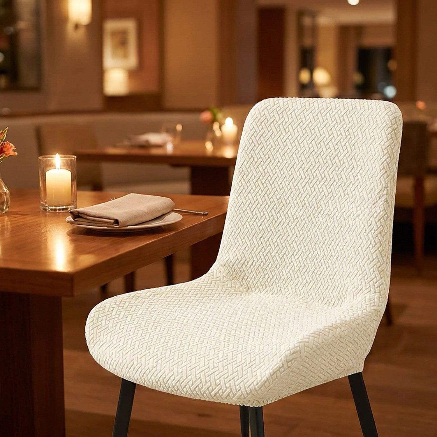 Chaise avec housse jacquard ivoire dans un restaurant chaleureux à la bougie