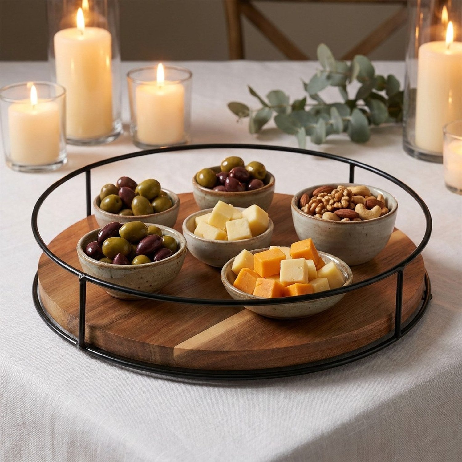 Plateau tournant en bois utilisé comme centre de table apéritif avec bols et bougies