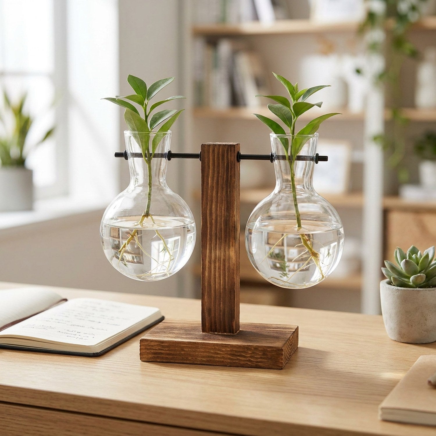 Deux vases à bouture alignés sur un bureau lumineux avec carnet et plante