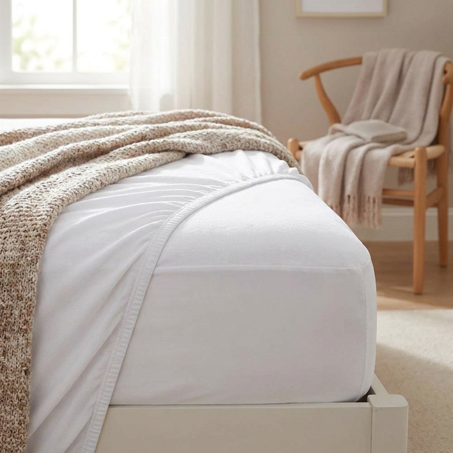 Coin de matelas avec housse blanche dans une chambre cosy et chaise en bois