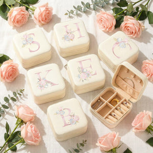 Boîtes à bijoux initiales disposées en cadeaux avec des roses roses