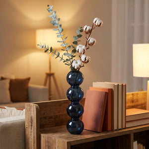 Vase en verre bleu nuit style nordique avec eucalyptus sur étagère