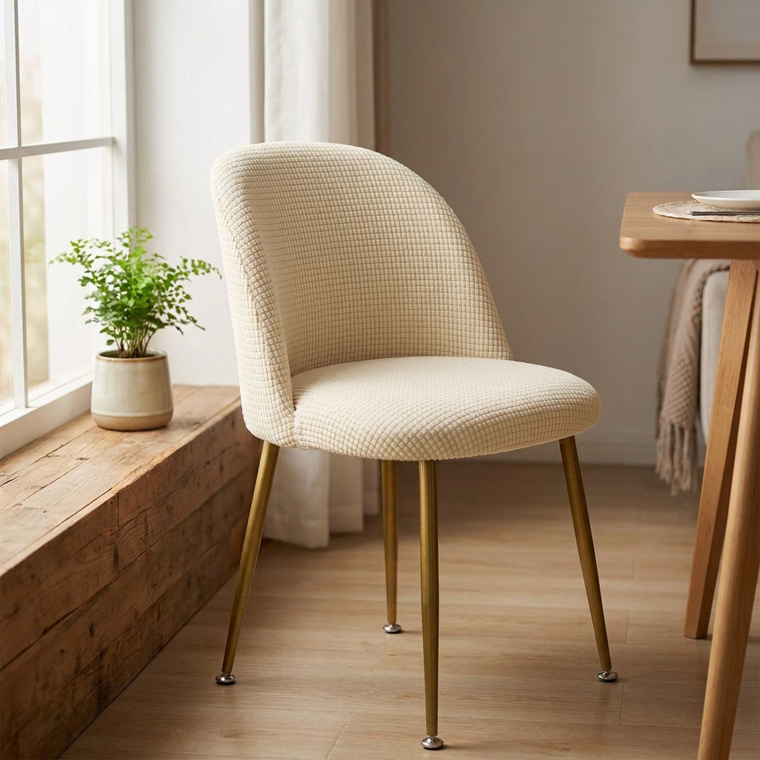 Housse de chaise beige installée près d'une fenêtre lumineuse dans un coin petit déjeuner cocooning