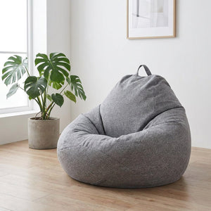 Pouf tatami gris dans un salon scandinave épuré avec plante monstera