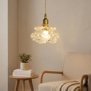 Suspension rose en verre nordique allumée dans un coin lecture avec fauteuil beige
