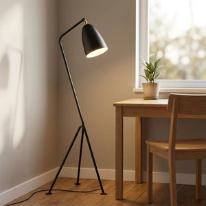 Lampadaire trépied noir dans un coin bureau en bois avec une plante verte