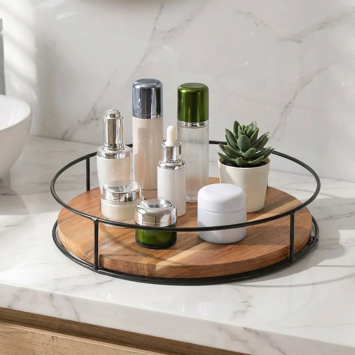 Plateau tournant en bois sur plan de salle de bain marbre avec produits cosmétiques