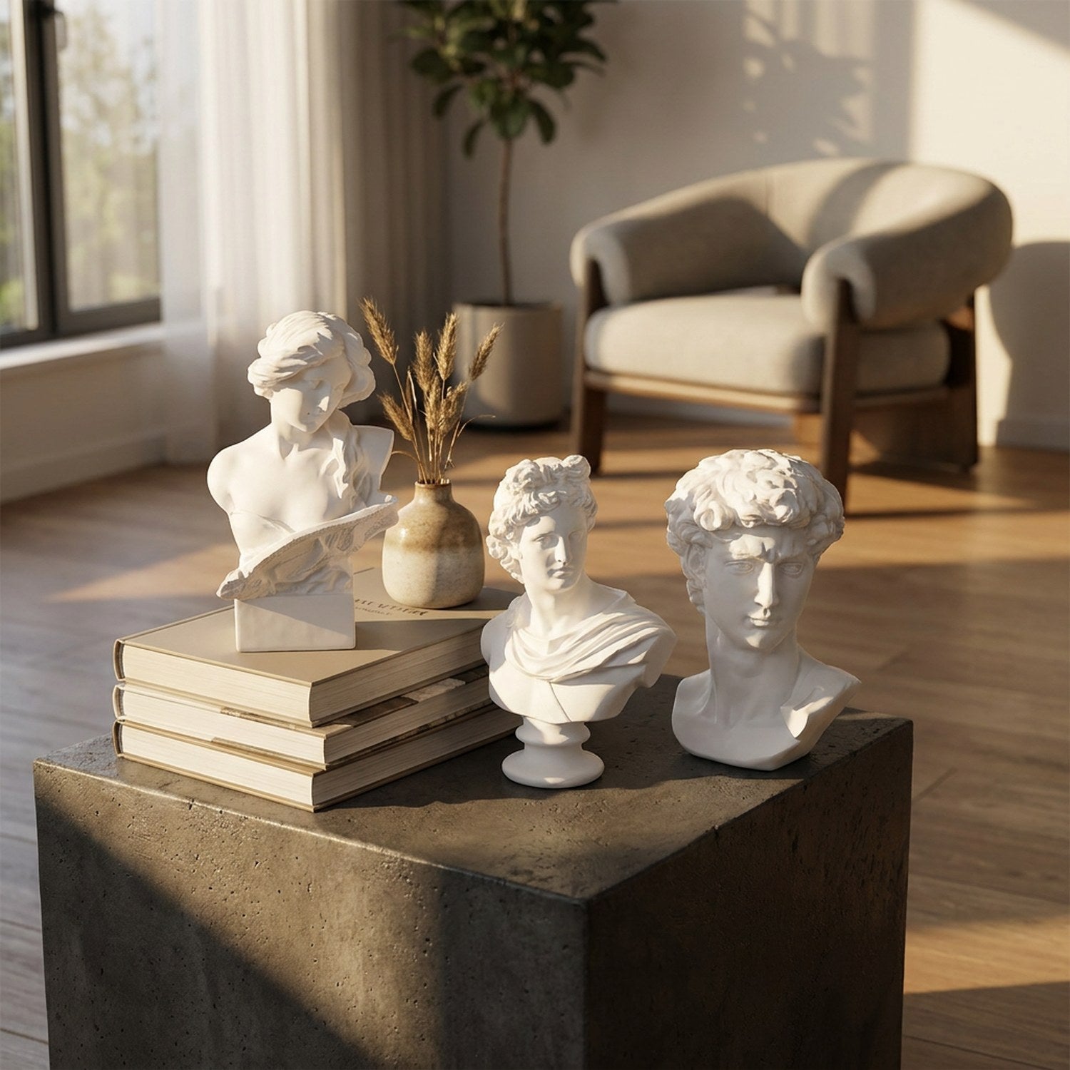 Trois bustes antiques en résine blanche disposés sur une table en béton avec des livres