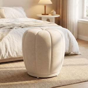 Pouf tabouret citrouille crème posé au pied d'un lit dans une chambre lumineuse