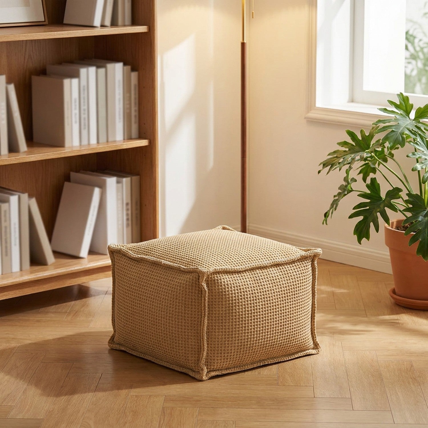 Pouf gaufré kaki en assise d'appoint dans un coin lecture lumineux