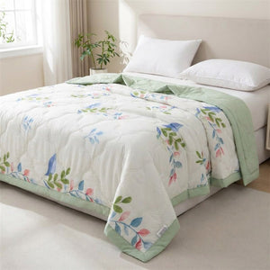 Couverture d'été à motif feuillage vert sur un lit dans une chambre fraîche