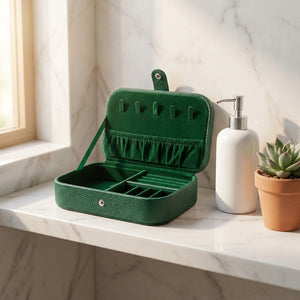 Boîte à bijoux voyage ouverte sur une étagère en marbre avec distributeur et plante