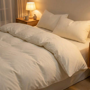 Parure de lit en coton lavé ivoire sur un lit dans une chambre chaleureuse le soir