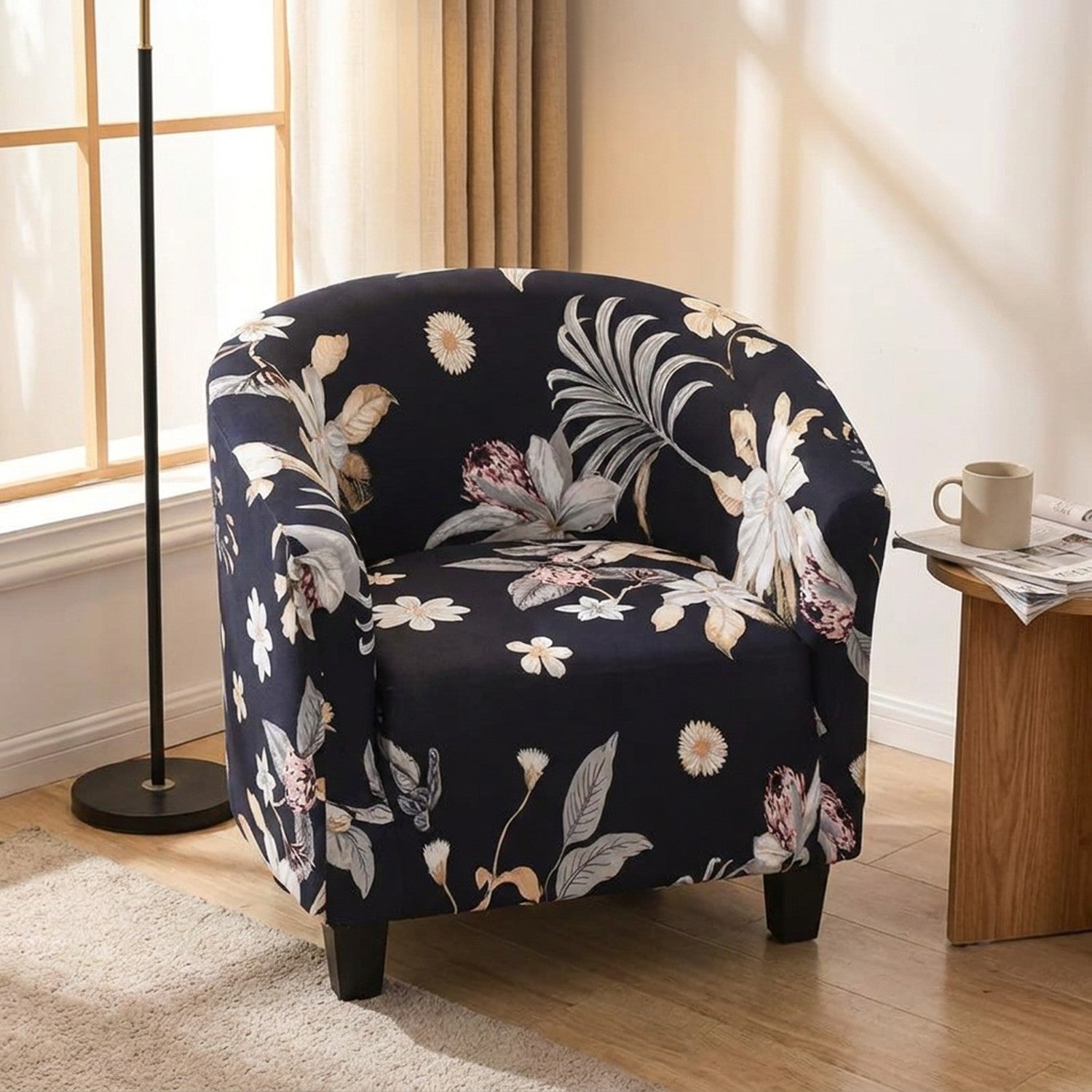 Fauteuil cabriolet habillé de sa housse florale marine dans un coin lecture avec lampadaire