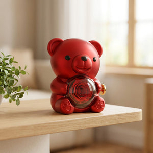 Boîte à bijoux ourson rouge posée sur une étagère en bois près d'une plante
