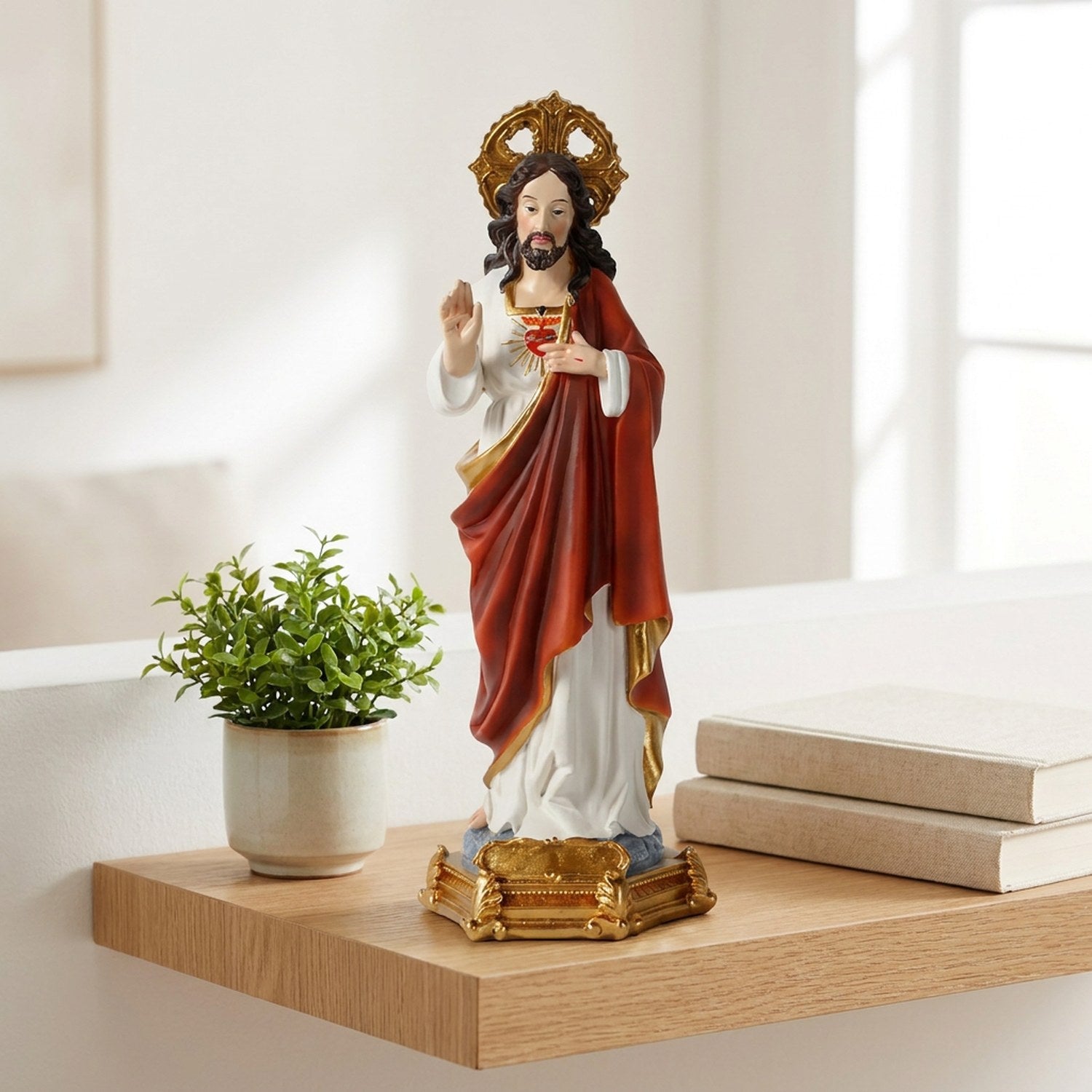 Statue du Sacré-Cœur de Jésus sur une étagère murale en chêne près d'une plante verte