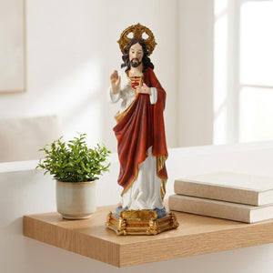 Statue du Sacré-Cœur de Jésus sur une étagère murale en chêne près d'une plante verte