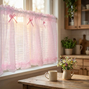 Rideau court en tulle rose suspendu à la fenêtre d'une cuisine cottage avec un bouquet de fleurs