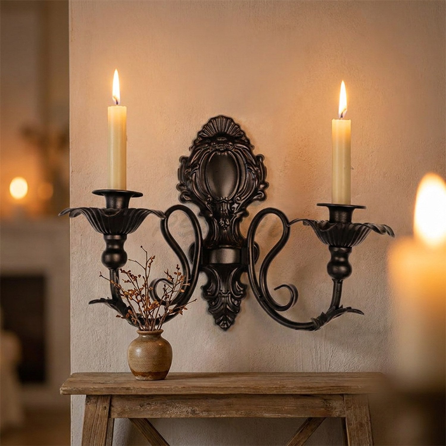 Bougeoir mural noir avec bougies allumées au-dessus d'une console en bois avec vase