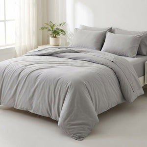 Parure de lit en coton lavé gris clair sur un lit dans une chambre lumineuse et minimaliste