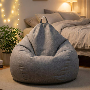 Pouf poire gris chiné dans une chambre cosy avec guirlande lumineuse