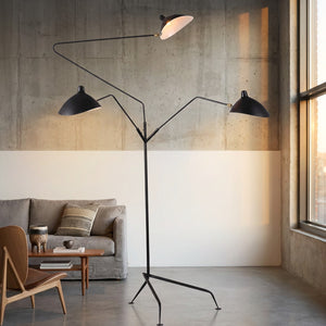 Lampadaire trépied trois bras articulés dans un loft industriel lumineux
