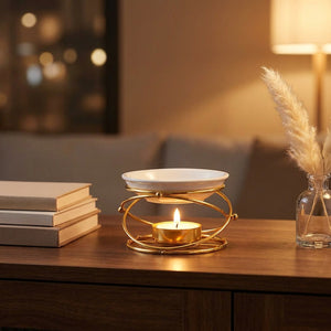 Brûle-parfum doré sur une console de salon avec livres et brins de pampa