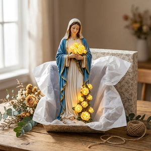 Statue Vierge Marie présentée comme cadeau dans un coffret sur une table en bois avec fleurs séchées