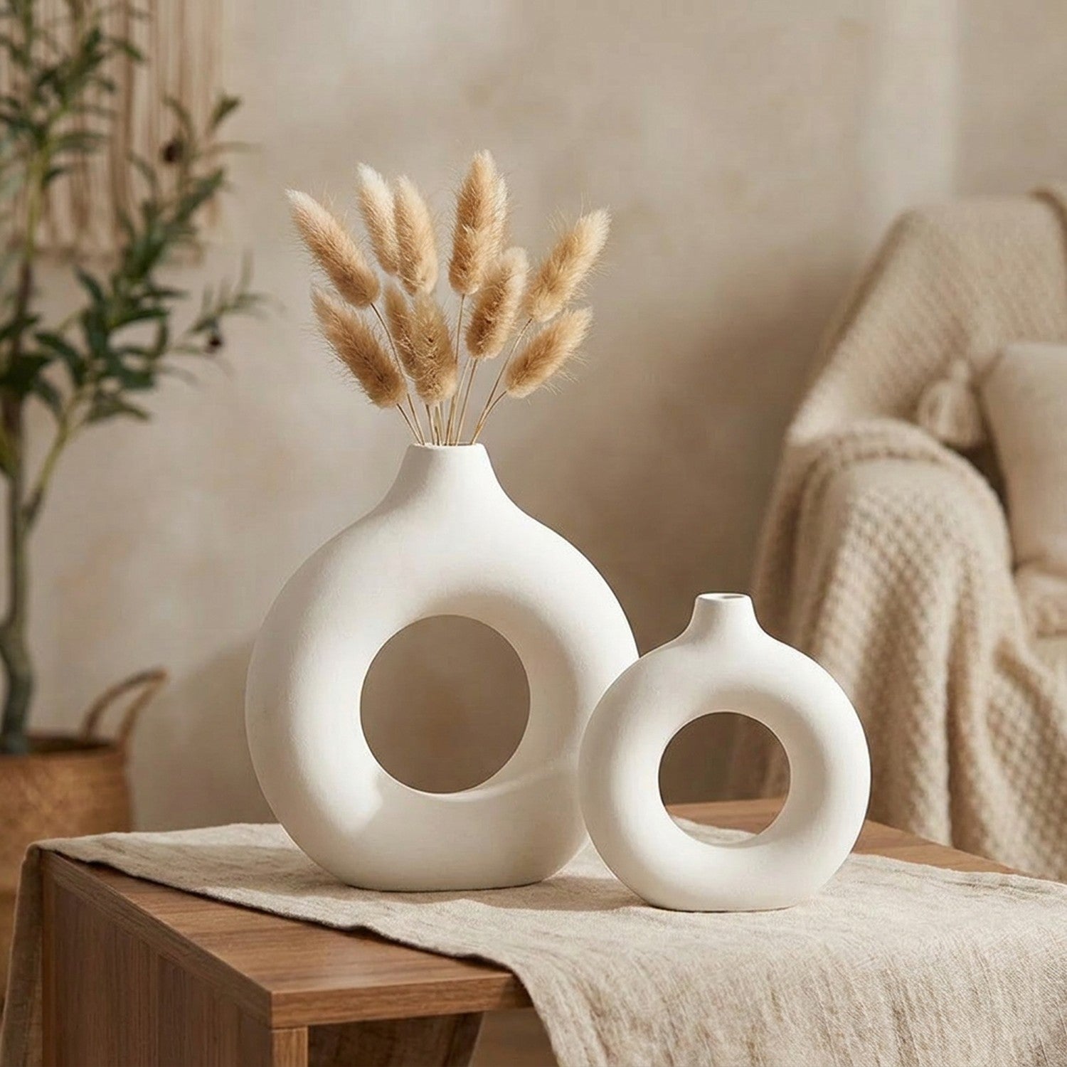 Deux vases anneau blancs de tailles différentes sur une table avec un chemin en lin