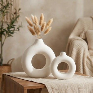 Deux vases anneau blancs de tailles différentes sur une table avec un chemin en lin