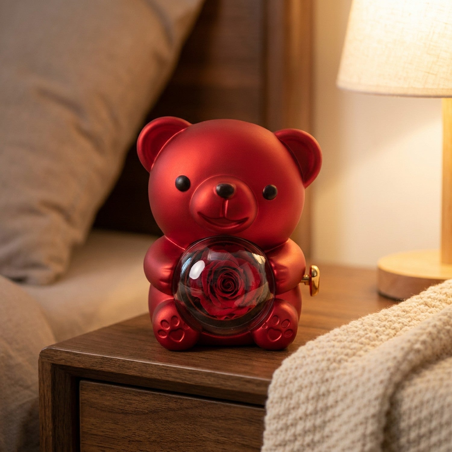 Boîte à bijoux ourson rouge sur une table de chevet avec un plaid