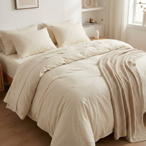 Parure de lit en coton lavé ivoire sur un lit cocooning avec un plaid beige