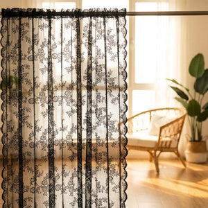 Rideau en dentelle noire à motif floral à contre-jour devant une grande fenêtre