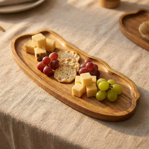 Plateau en bois présentant fromages crackers et raisin pour l'apéritif