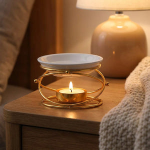 Brûle-parfum doré sur une table de chevet avec lampe allumée le soir
