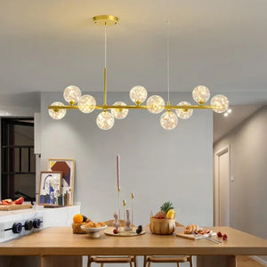 Lustre doré à boules de verre pailleté au-dessus d'une table en bois