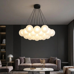 Lustre à boules de verre blanc laiteux avec cadre noir suspendu dans un salon contemporain sombre lampe allumée