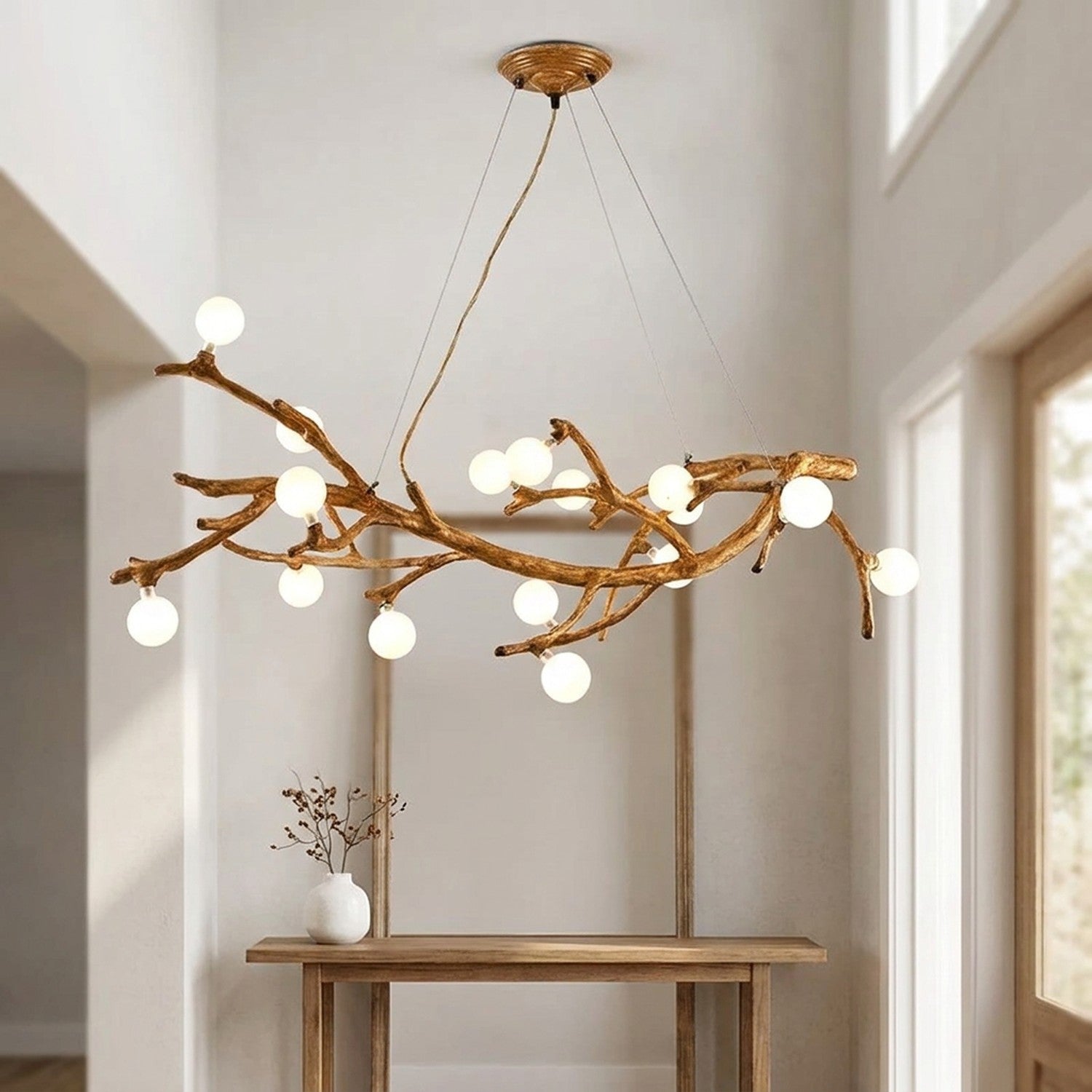 Lustre branches d'arbre suspendu dans une entree lumineuse au-dessus d'une console
