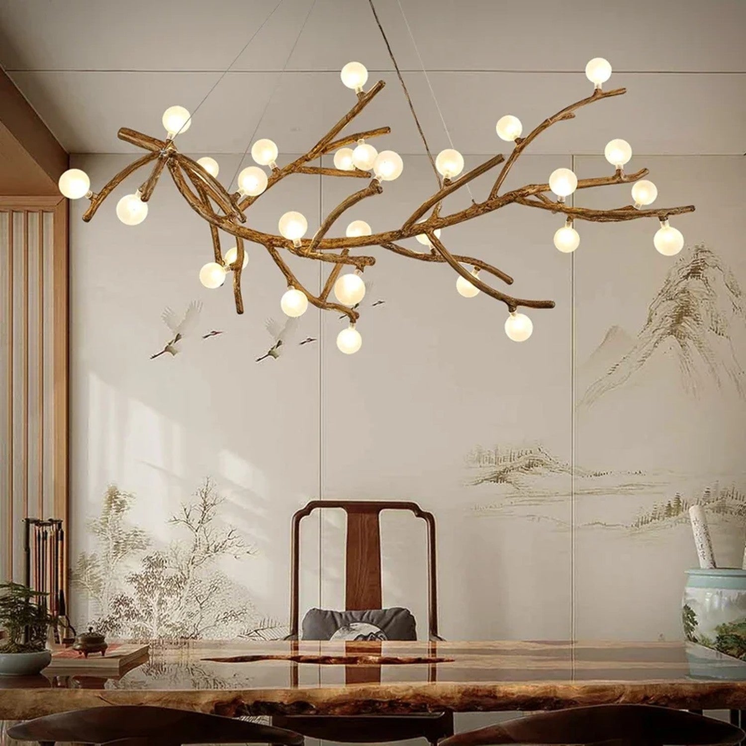 Lustre branches d'arbre avec boules lumineuses au-dessus d'une table basse