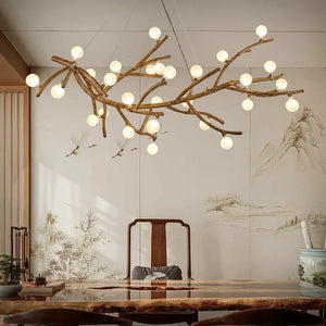 Lustre branches d'arbre avec boules lumineuses au-dessus d'une table basse