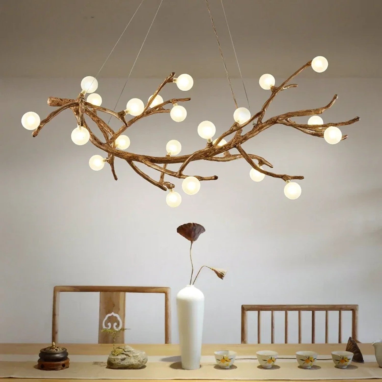 Lustre branches d'arbre suspendu au-dessus d'une table a manger avec vase