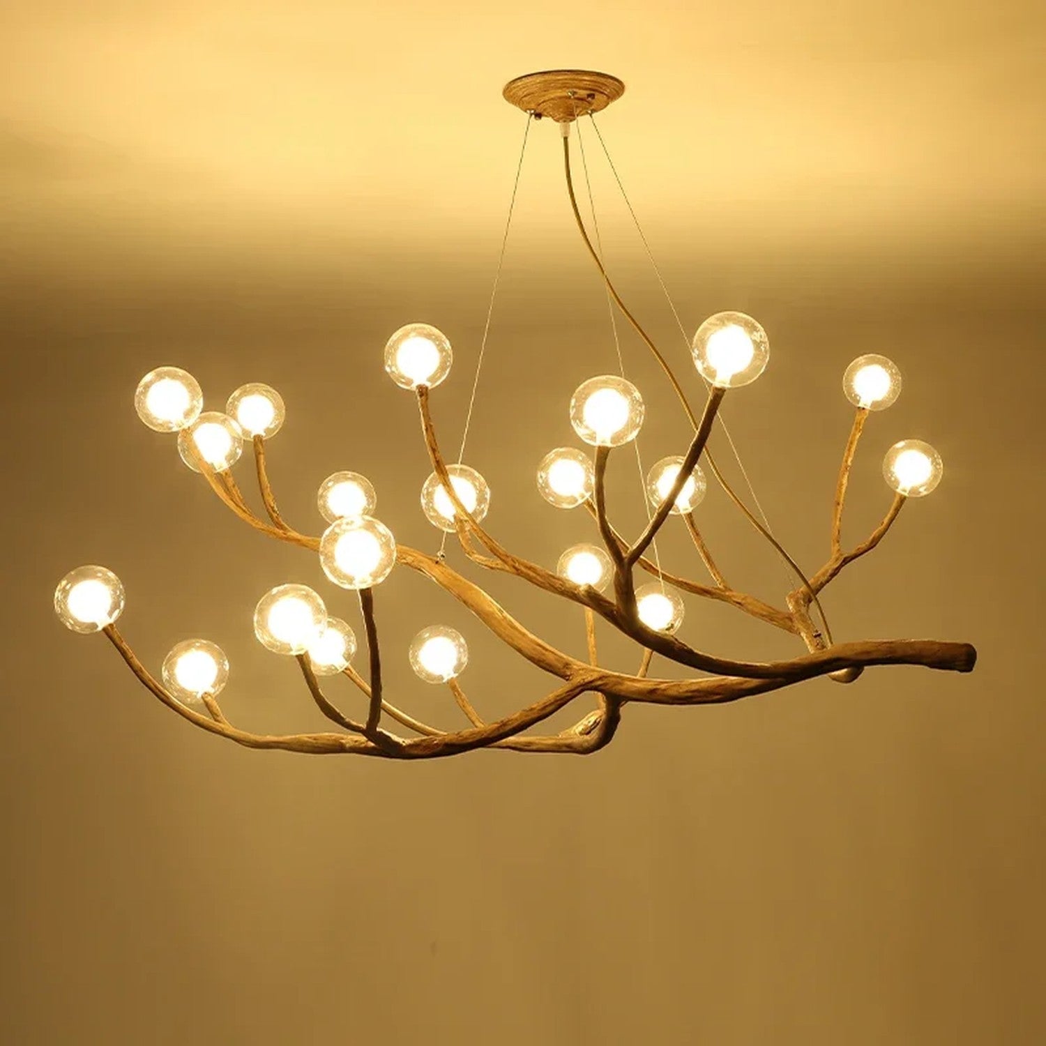 Lustre branches d'arbre en gros plan avec boules en verre transparent allumees