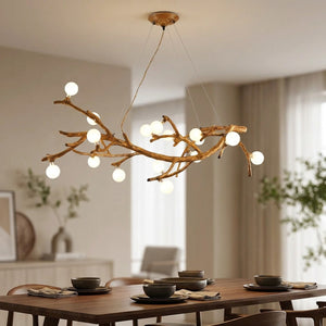 Lustre suspendu en forme de branche d'arbre avec 16 boules en verre givré lumineuses façon lucioles au-dessus d'une table à manger en bois